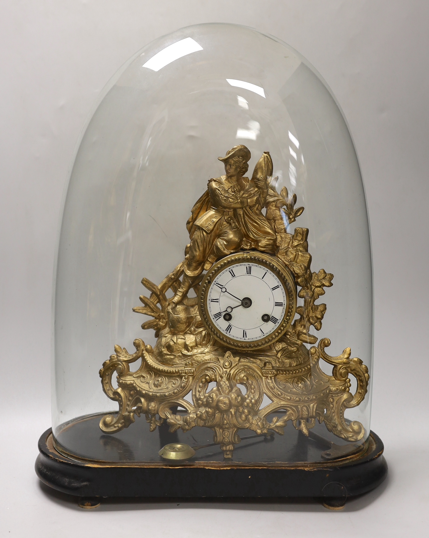 A 19th century gilt-spelter figural mantel clock, on stand under a glass dome, total height 47cm